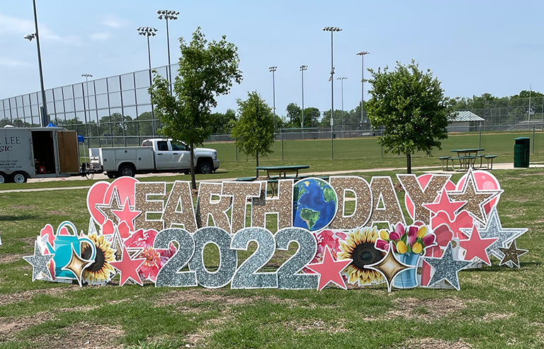 2022 Earth Day sign in front of baseball field
