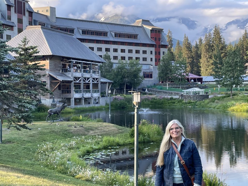Sue Makuta standing in front of a Mountain Resort in Colorado.