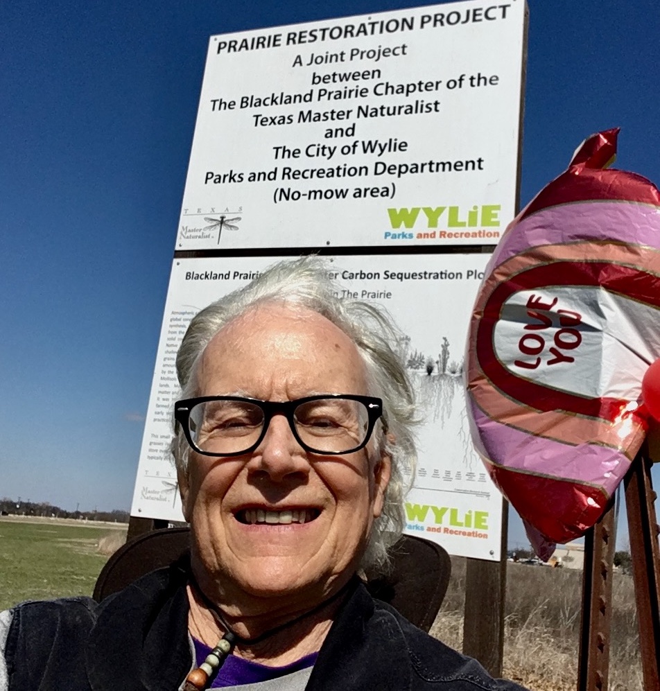 Jay Wooldridge smiling in front of the Wylie Prairie sign.