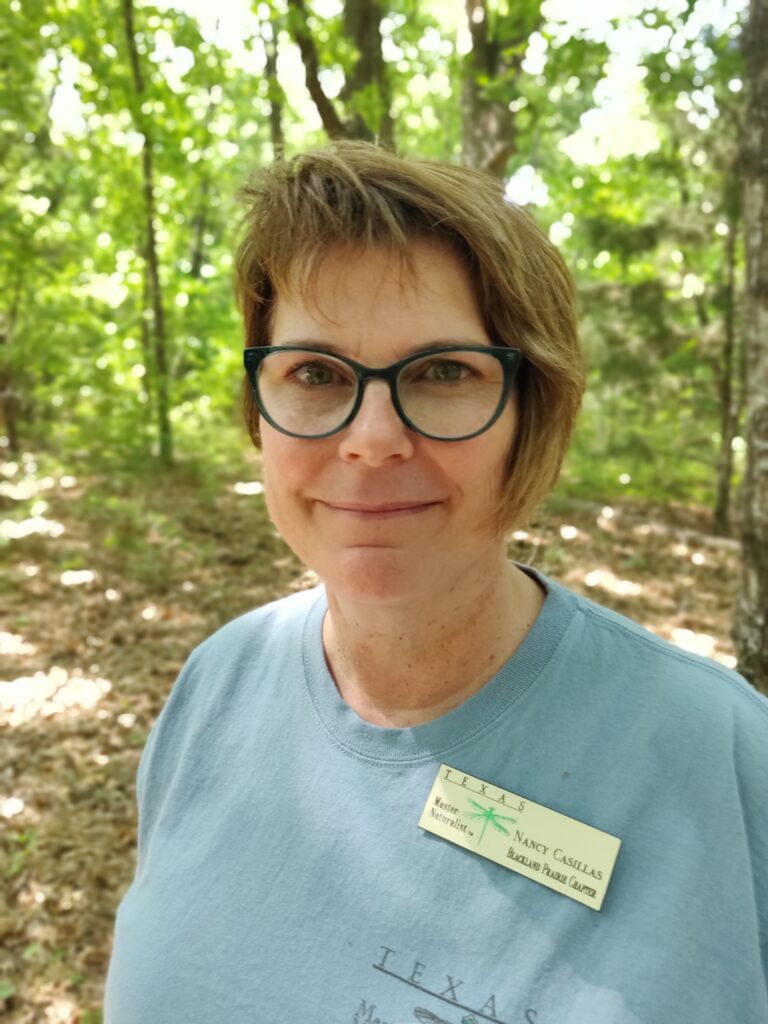 Nancy Casillas smiling on a nature trail.