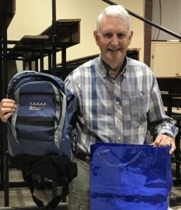 photo of member Dave Redden holding backpack with TMN dragonfly logo