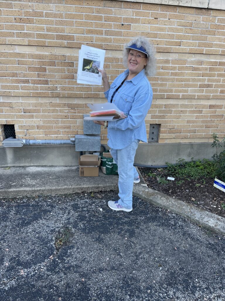 a woman holding a picture of a butterfly and a stack of photographs and signs