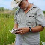 JJ White looks through field guide.