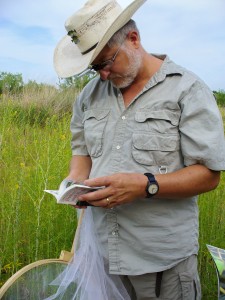 JJ White looks through field guide.