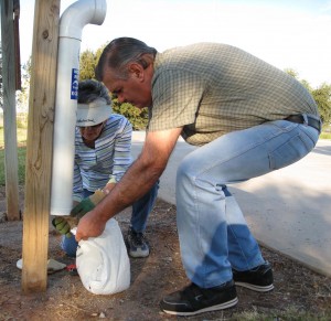 Martha and Earl remove fishing line from the monofiliament recycling bin at the lake.