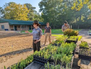 Big Thicket Rangers discussing the native plant distribution in the pollinator garden at the Big Thicket FRSLC in Saratoga.